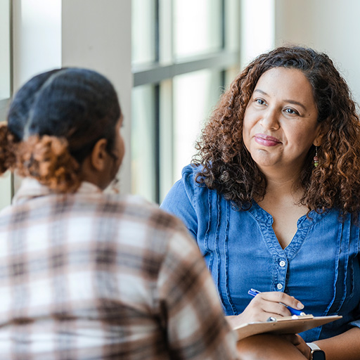 Eine Frau führt mit einem Mädchen ein Bewerbungsgespräch