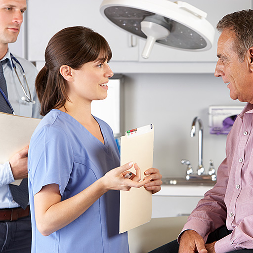 Eine Ärztin unterhält sich mit einem älteren Patienten.