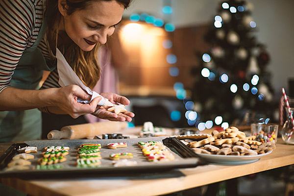 Junge Frau dekoriert Weihnachtslätzchen